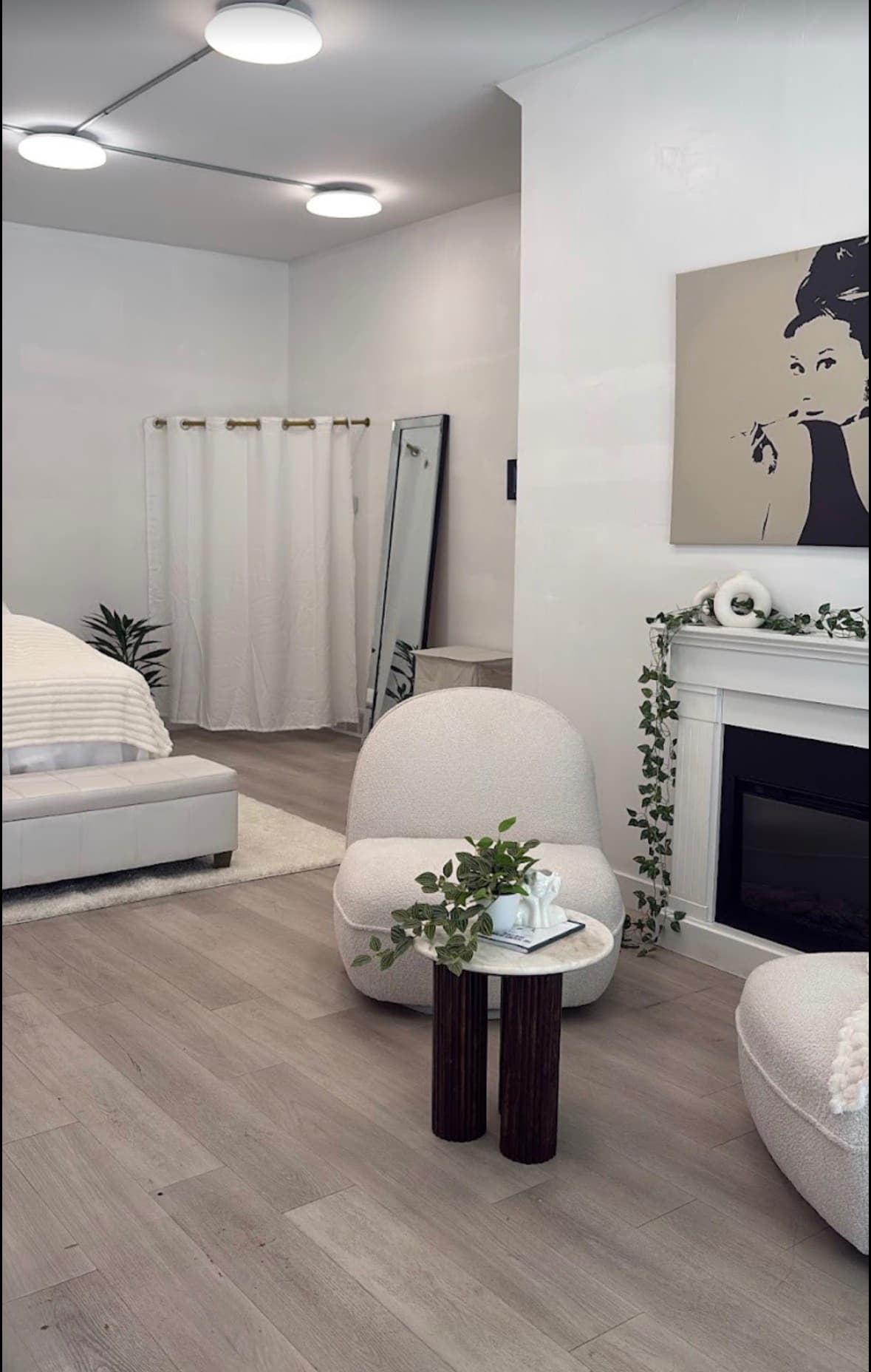The lounge corner at Aurora Skin Co., with a boucle chair, fireplace and plants